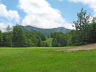 6th Green at Killington Resort Golf Course with Killington and Skye Peaks in the background.