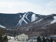 High thin clouds filter sunshine over Killington Peak