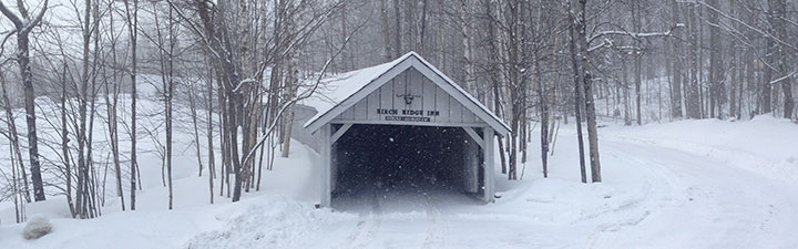 Fresh snow drapes the Covered Carriageway at the Birch Ridge Inn